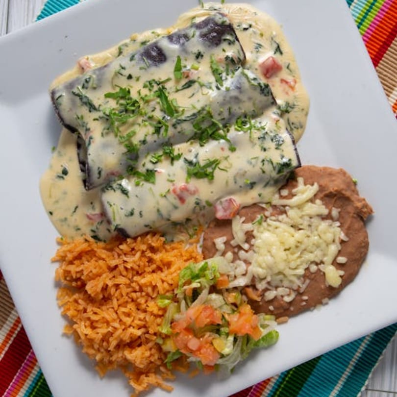 Agavero's Mexican Bar and Grill's enchiladas with creamy sauce, rice, refried beans, and salad.